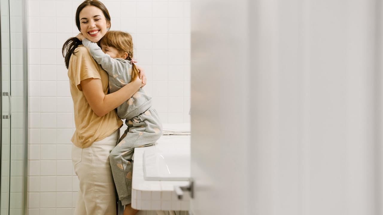 Mare i filla abraçant-se al wc de casa