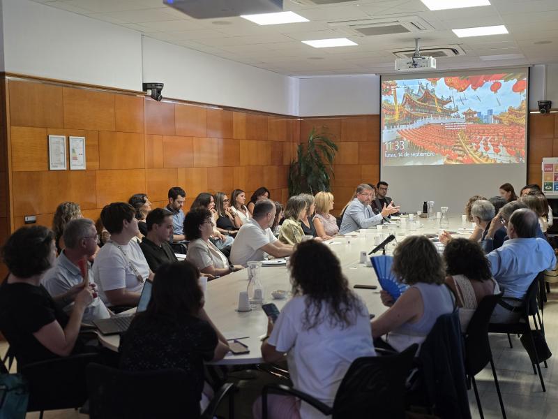 Una trentena de persones reunides al voltant d'una taula en una sala del CSC