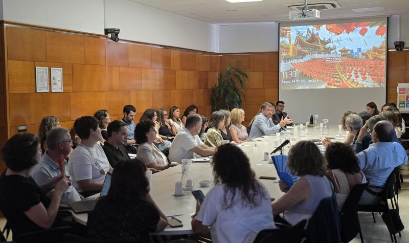 Una trentena de persones reunides al voltant d'una taula en una sala del CSC